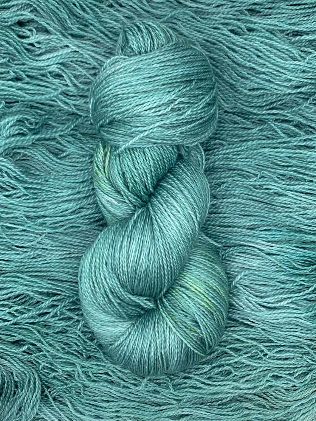 Hand dyed Superwash Merino cashmere and silk lace yarn in soft blue green teal