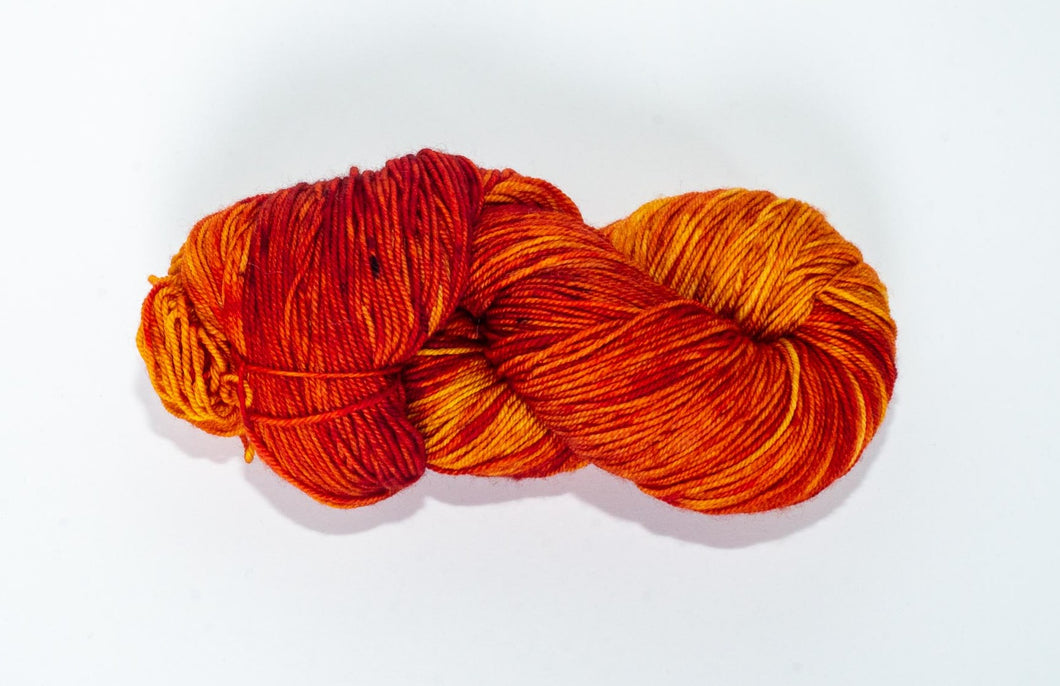 Hand Dyed Fingering Weight Superwash Merino cashmere nylon yarn in red orange and yellow with brown speckles