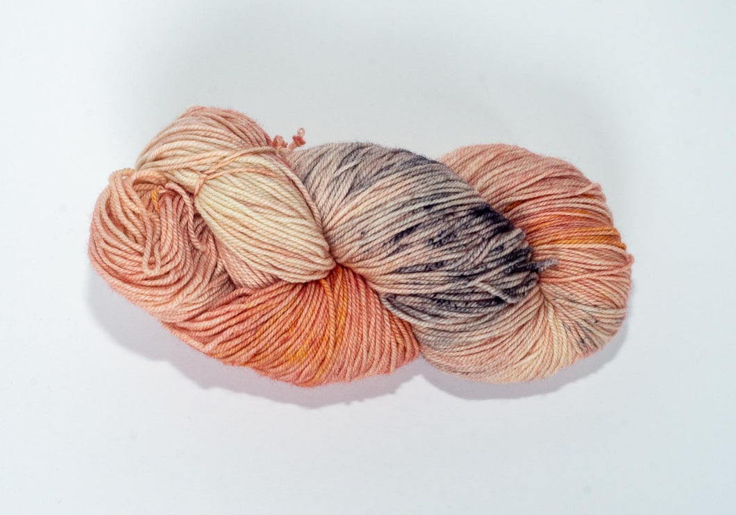 Hand Dyed Fingering Weight Superwash Merino cashmere nylon yarn in peachy pink with gray speckles