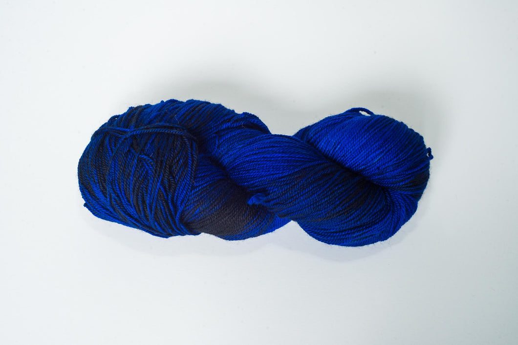 Hand Dyed Fingering Weight Superwash Merino cashmere nylon yarn in vibrant cobalt blue and black